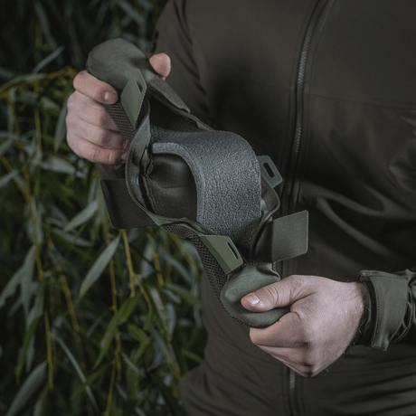 Person håller M‑Tac axelremspad 50 mm Elite tillverkad av slitstarkt Cordura med 3D-mesh för komfort och viktfördelning.