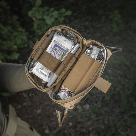 M-Tac Horizontal Medical Pouch Elite i bruk, öppen väska visar innehåll av fältkit för första hjälpen i Cordura 500D med YKK AquaGuard-dragkedja.
