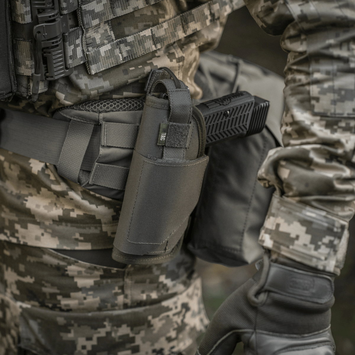 M-Tac Universal Taktisk Hylster Elite Venstre monteret på soldat med MOLLE-interface og camouflagemønster.