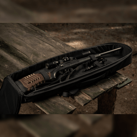 M-Tac Gun Backpack Case 105 cm Elite Hex med AR-15 demonterad på ett bord i skogen, visar inre indelning.