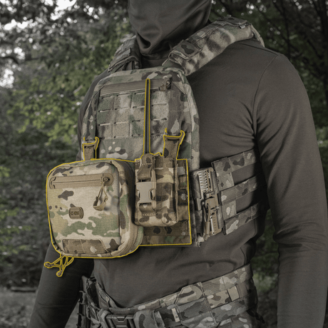 M‑Tac Front Panel för Cuirass QRS monterad på en taktisk väst med MOLLE-system och magasinförvaring i skogsmiljö.