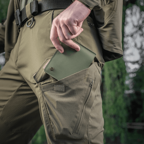 M-Tac Plånbok Slim Elite Gen. II i grön, dras ut ur byxficka, visar kompakt design och modern produktionsteknik.