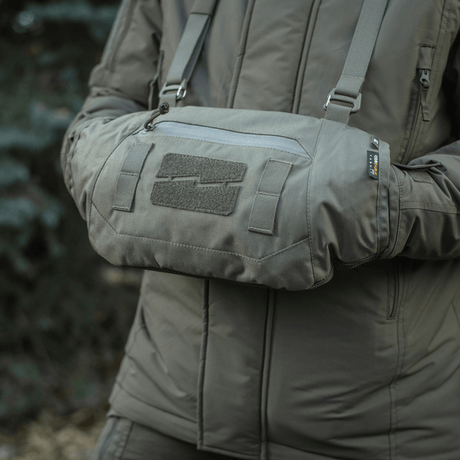 Person använder M-Tac Taktisk Handvärmare Elite i grått, tillverkad av Cordura med Polartec-fleecefoder, idealisk för kallt väder