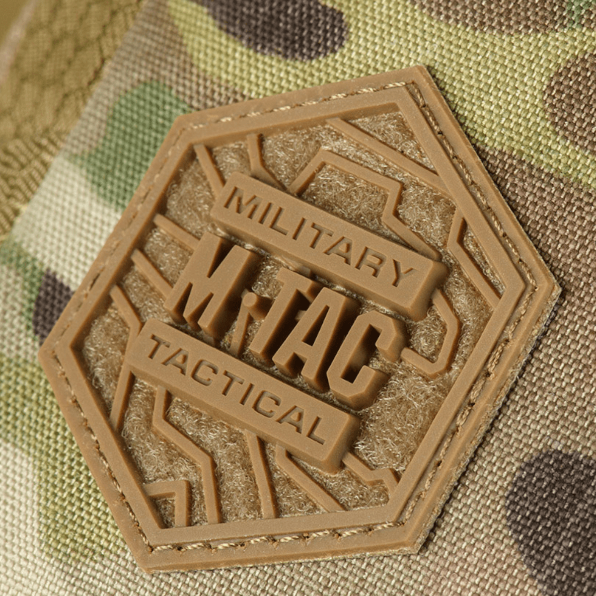 Nærbillede af M-Tac Sling Pistoltaske Elite Hex logo på camouflage baggrund