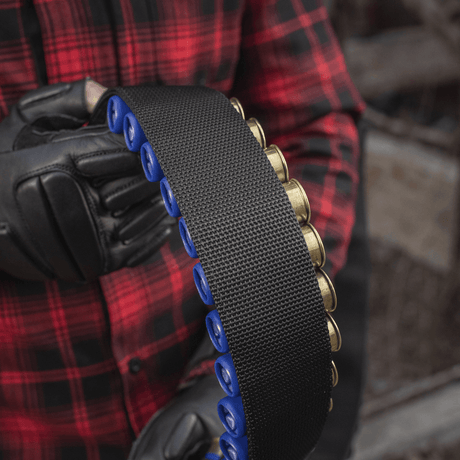En person håller M-Tac Bandolier Elite, ett patronbandolier för 55 patroner, idealiskt för jakt och sportskytte.