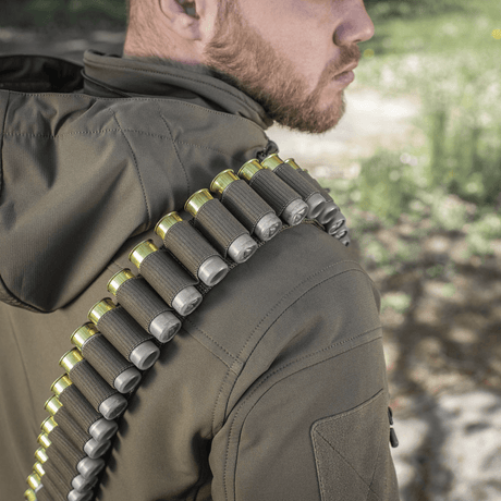 M-Tac Bandolier Elite bärs av person, visar patronbandolier för jakt och sportskytte. Praktisk design, kapacitet 55 patroner.