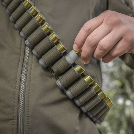 Person bär M-Tac Bandolier Elite fylld med ammunition för jakt och sportskytte.