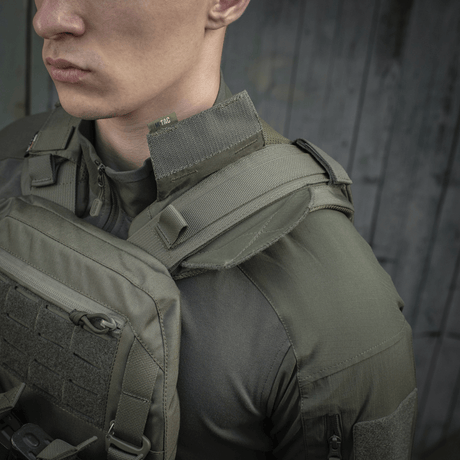 M-Tac axelpad till Plate Carrier Cuirass QRS monterad på axeln, visar hållbar Cordura och inre 3D-mesh-paneler för ventilation
