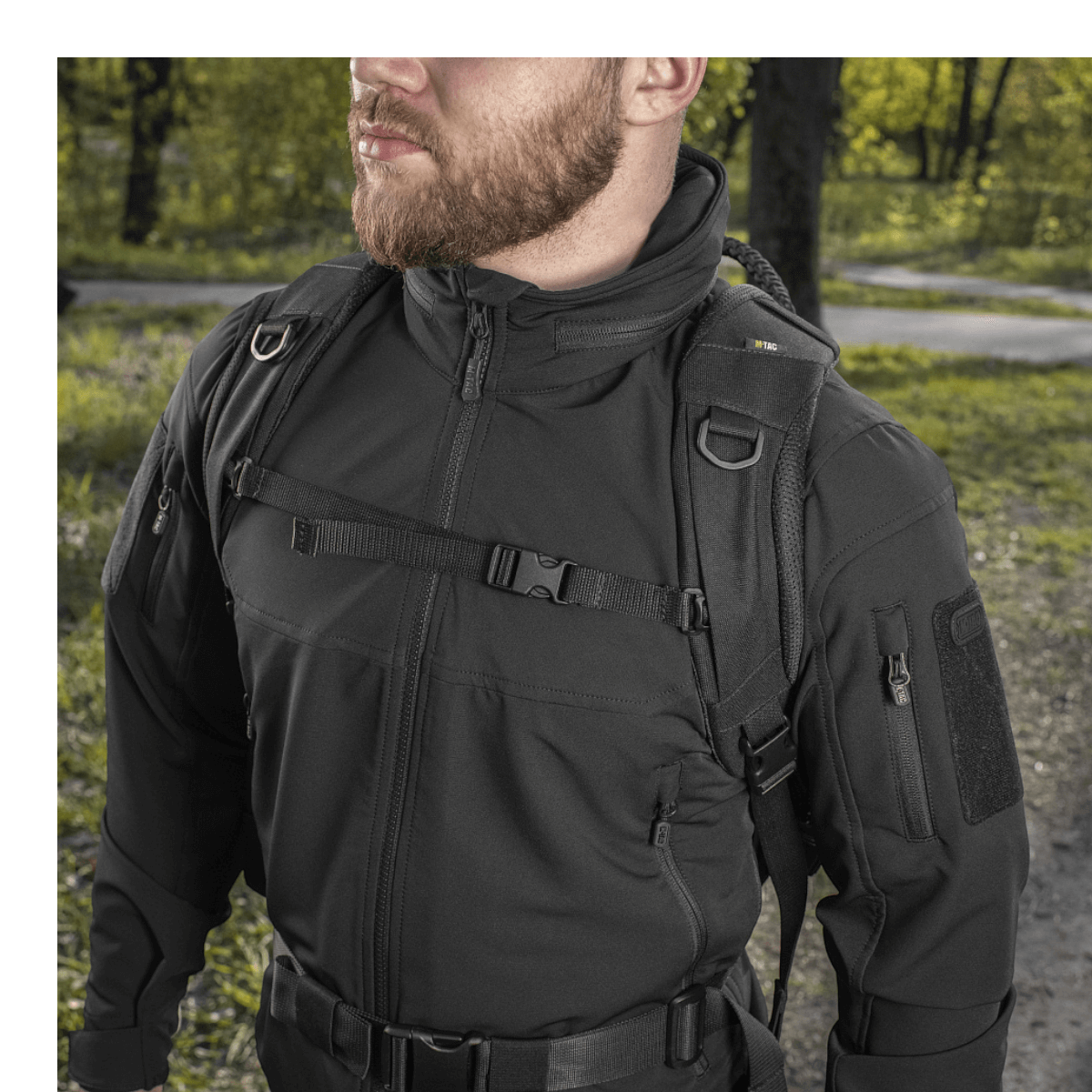 Mand iført M-Tac Mission Pack Elite rygsæk i sort, designet med slidstærkt Cordura 1000D og MOLLE LASER CUT-system, udendørs.