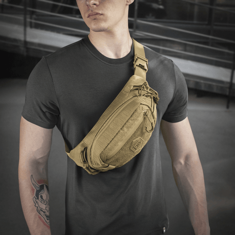 Person med M‑Tac Bältesväska Elite Hex i stilrent design, idealisk för vardag eller taktisk användning. Tillverkad i Cordura med kvalitetsdragkedjor.