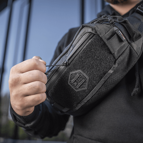 M‑Tac bältesväska Elite Hex i bruk, visar hållbar design i Cordura-tyg med YKK-dragkedja och Woojin-spännen, perfekt för vardagligt bruk.