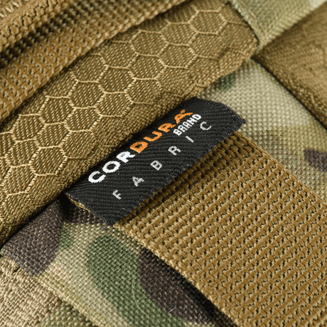Närbild av Cordura-tygetikett på M‑Tac bältesväska Elite Hex, visar den robusta och stilrena designen av väskan.