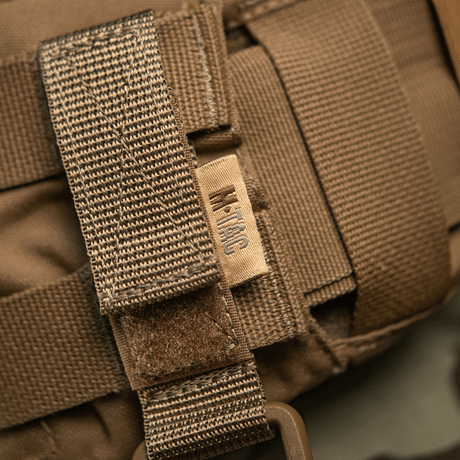 M-Tac fäste med D-ring på MOLLE-system med Velcro.