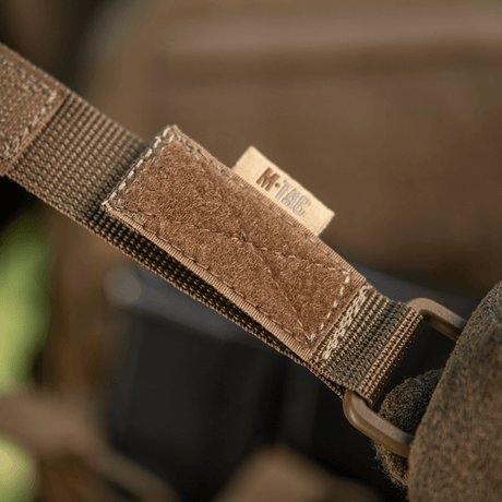 M-Tac fäste med D-ring för MOLLE-utrustning på väska med Velcro-låsning, idealisk för taktisk användning. Kompakt och lätt.