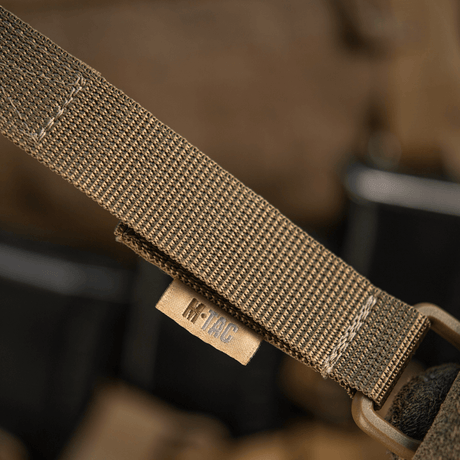 M-Tac fäste med D-ring för MOLLE-system med Velcro-låsning, perfekt för taktisk användning på ryggsäckar och västar.