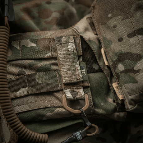 M-Tac fäste med D-ring på kamouflageväst med MOLLE-system och Velcro-låsning, idealisk för taktisk användning och montering av utrustning.