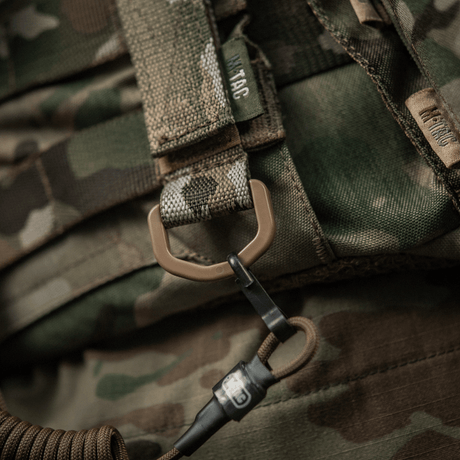 M-Tac fäste med D-ring för MOLLE-utrustning på kamouflagevästar.