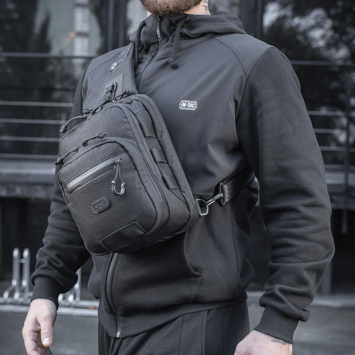M-Tac Cross Taske Slim Elite Hex bæres af en person iført sort tøj, fremstillet i slidstærkt Cordura stof.