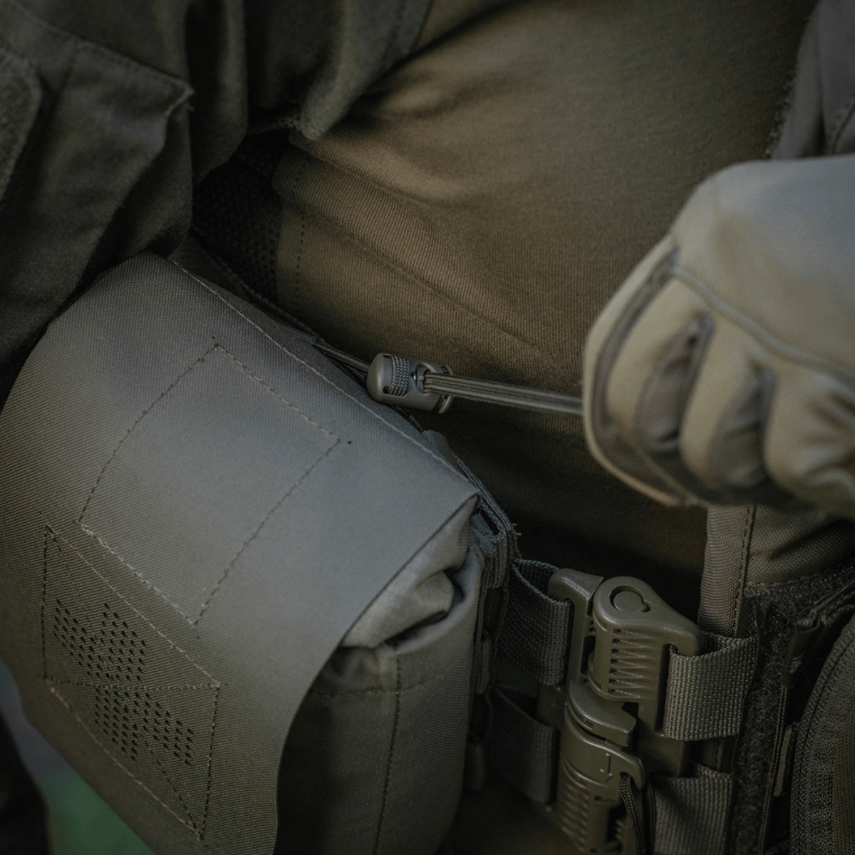 M‑Tac Medic Pouch Vertical Large Elite i brug, detalje af solid Cordura 500D stof og MOLLE system på innovativ førstehjælpstaske.