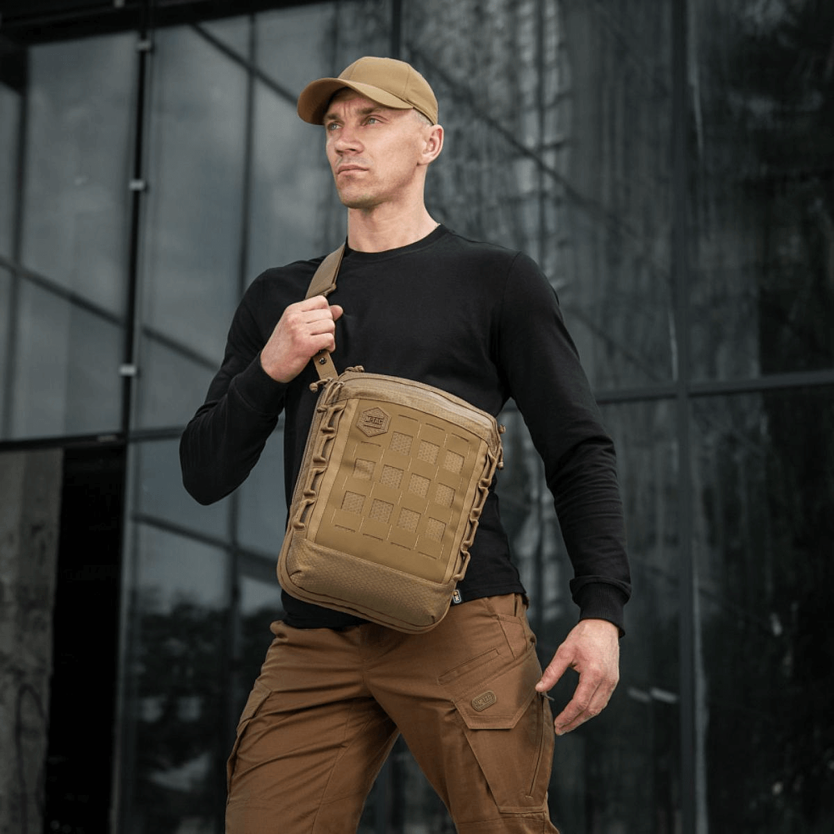 Mand bærer M-Tac Tablet Bag Laser Cut Hex i taktisk miljø, viser taskens MOLLE system og holdbare materiale.