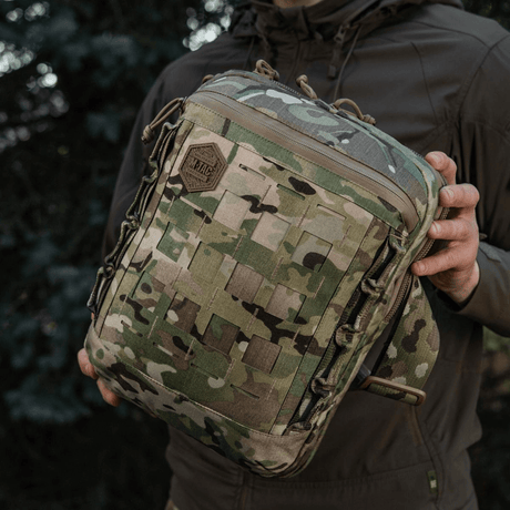 M-Tac Tablet Bag Laser Cut Hex i camouflage design holdes i hånden, viser frontpanel med Laser Cut MOLLE system for ekstraudstyr.