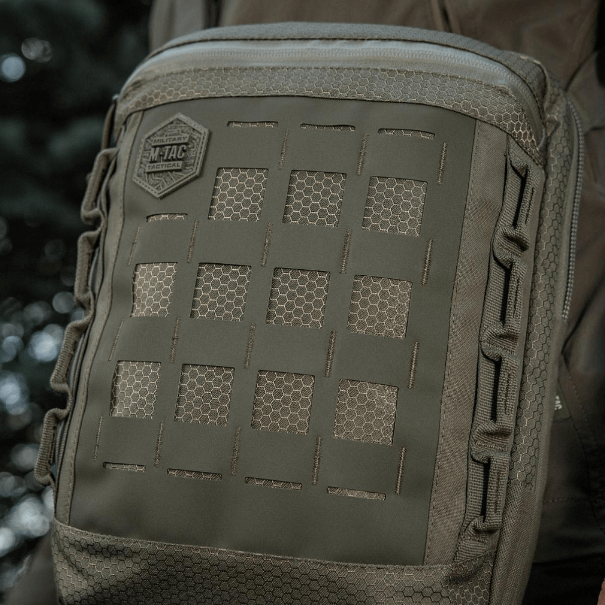 M-Tac Tablet Bag Laser Cut Hex i Cordura stof med Laser Cut MOLLE design, ideel til EDC, dokumenter og tablet, i naturligt miljø.
