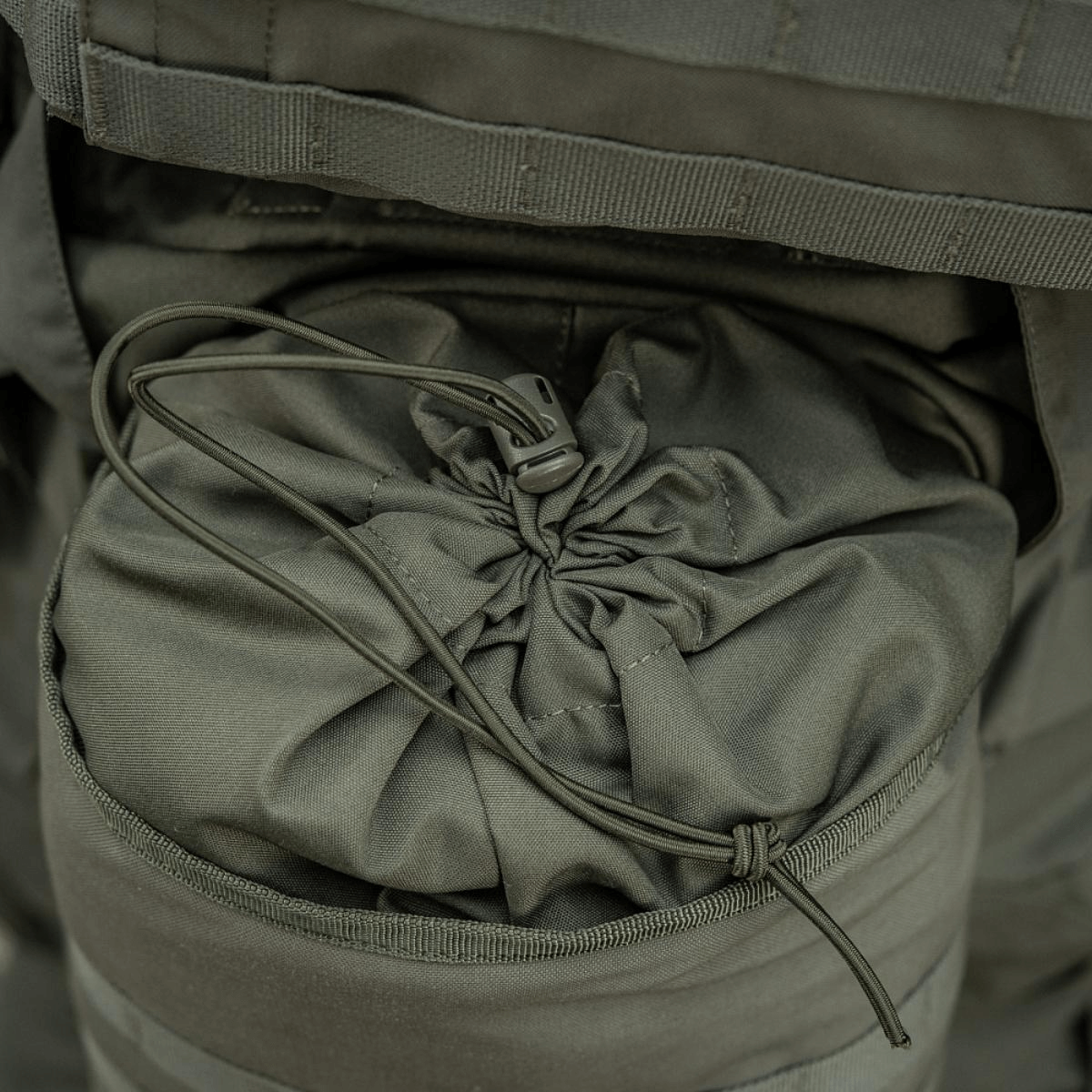 M-Tac Sukharka Gen.3 Pouch i Cordura 500D med elastik og snor i brug, ideel til militær brug og udstyrsmontage via MOLLE-interface.