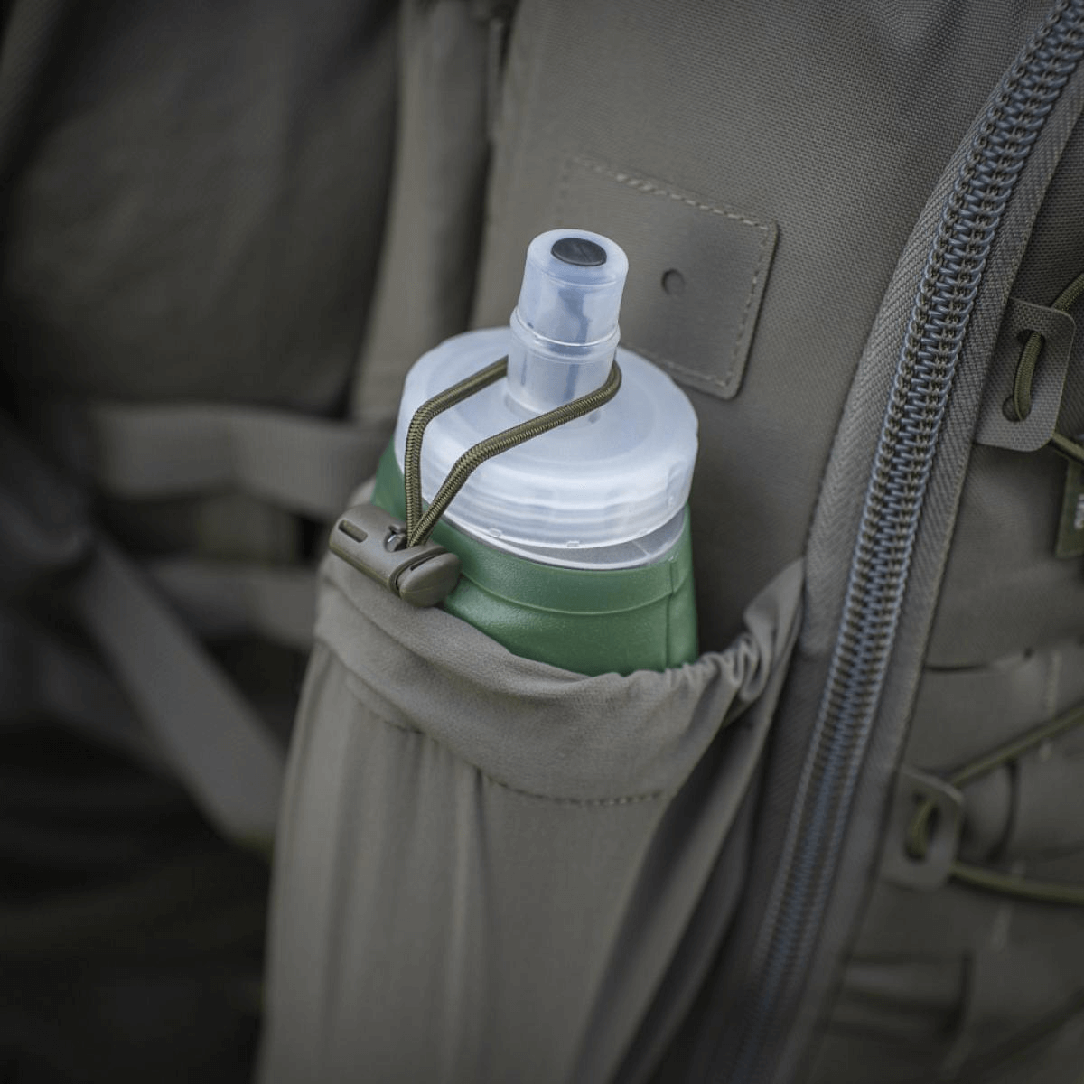 Drikkedunk i sidelomme på en rygsæk, praktisk til udendørs eventyr.