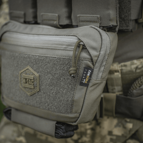 M-Tac Large Elite Gen.II Skuldertaske i brug med Cordura 500D stof og YKK lynlåse, vist på taktisk udstyr.