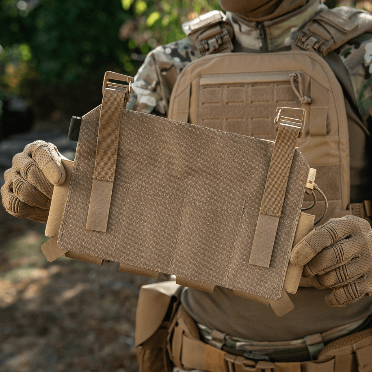 M-Tac Frontpanel til Plate Carrier Cuirass QRS til 4 Magasiner holdt af en person iført taktisk udstyr i naturen.
