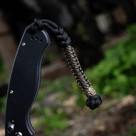 M‑Tac Knife Lanyard Scandinavian – flätad paracord-lanyard på fickkniv för stilfull och praktisk användning.