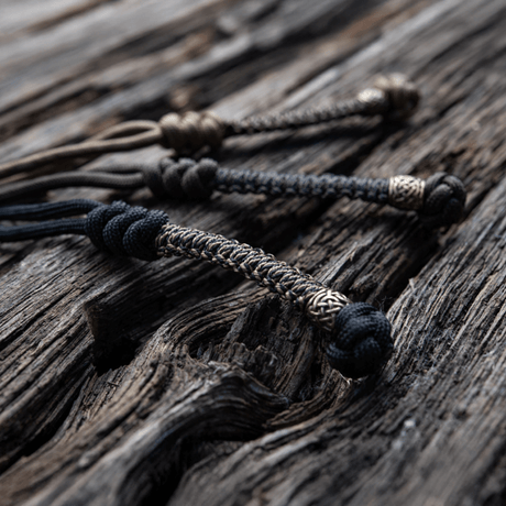 M‑Tac Knife Lanyard Scandinavian flätad paracordtillägg till fickknivar på träyta, stilfullt och praktiskt tillbehör.