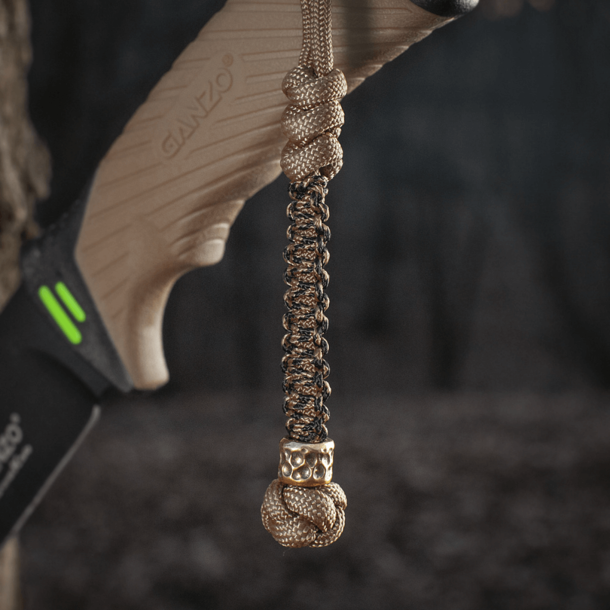 M-Tac Knife Lanyard Scandinavian Granule i flettet paracord på kniv, stilfuldt tilbehør og praktisk forlængelse af knivskaft.