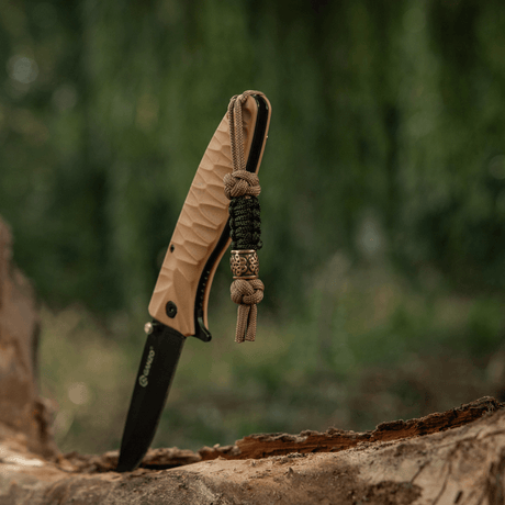 M-Tac Lanyard Scandinavian Small Chinese Knot på en kniv, gjord av snodd paracord och prydd med skandinaviska motiv i naturmiljö