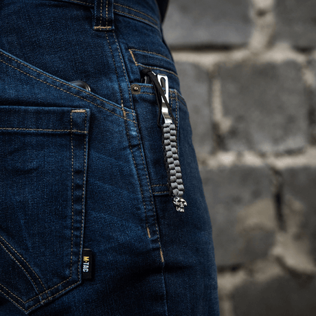 M-Tac Knife Lanyard Cuboid Skull fäst vid jeans med flätad paracord-design och dekorativ skallepärla.
