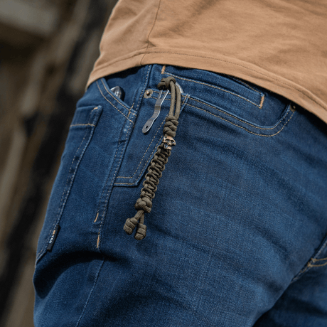 M-Tac Loopy Snake Skull Lanyard i paracord på jeans, stilfullt och praktiskt tillbehör för knivar, ficklampor och annan utrustning.