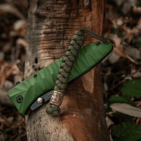 M-Tac Viper Lanyard Scandinavian i paracord med Viper-pärla i naturlig miljö, idealisk för knivar och ficktillbehör, slitstark och stilfull.