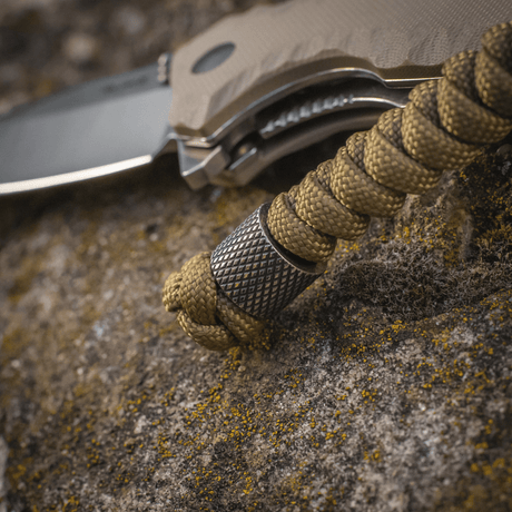 M-Tac Viper Lanyard Stainless Steel med flätad paracord och rostfri stålpärla på kniv, stiligt tillbehör för snabb åtkomst.