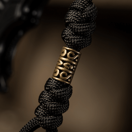 Detaljbild av M-Tac Zeus Lanyard med flätad paracord och dekorativ mässingsbit, perfekt för kniv och utrustning.