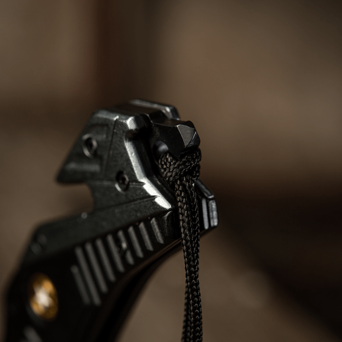 Detaljebillede af M-Tac Zeus Lanyard, flettet med paracord for hurtig adgang og stilfuldt design, knyttet til knivhåndtag.