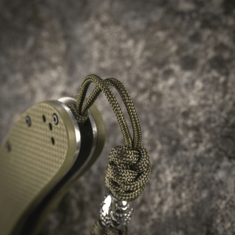 M-Tac Zeus Stainless Steel Lanyard med flätad paracord och dekorativ pärla, fäst vid kniv för flexibel åtkomst och hållbarhet.