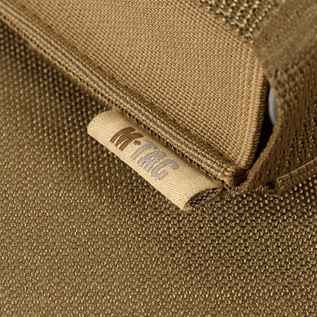Detalj av M-Tac Gasdåseholder Vertikal med MIL‑SPEC‑rem i brunt tygmaterial och märkt logotyp.