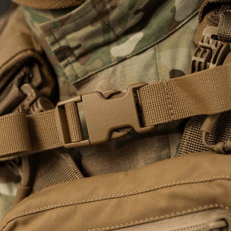 Närbild av M-Tac Rygsäck Sturm Elite Gen.II med robust spänne och camouflagbakgrund, idealisk för taktiska aktiviteter.
