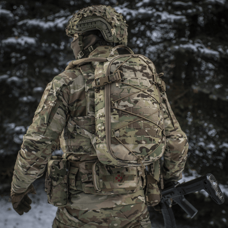 Soldat bär M-Tac Rygsäck Sturm Elite Gen.II i snötäckt skog med MOLLE Laser Cut-system och elastisk snörning för utrustning.