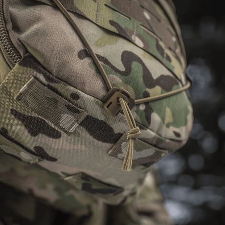 Närbild av M-Tac Rygsäck Sturm Elite Gen.II med camouflagemönster och bungee-snöre för utomhusutrustning.
