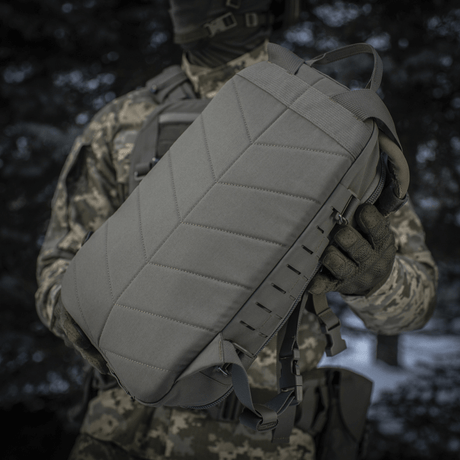 Taktisk M-Tac Ryggsäck Sturm Elite Gen.II hålls av person i kamouflageutrustning.