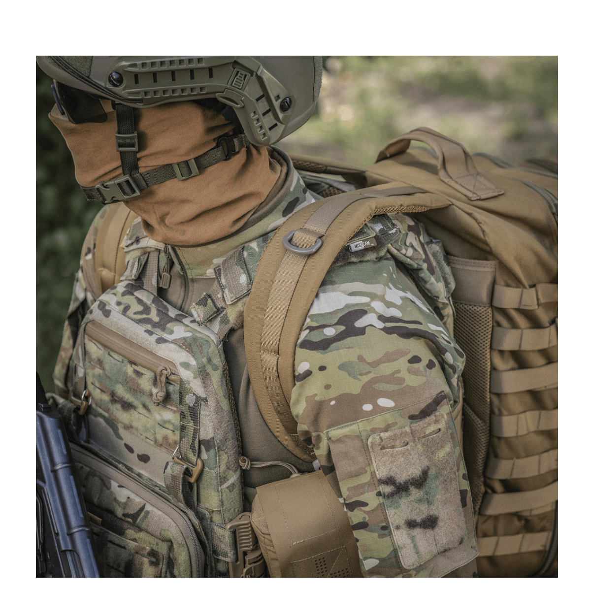 Person med camouflageudstyr bærer M-Tac Large Assault Pack Rygsæk med MOLLE-system og polstrede skulderremme.