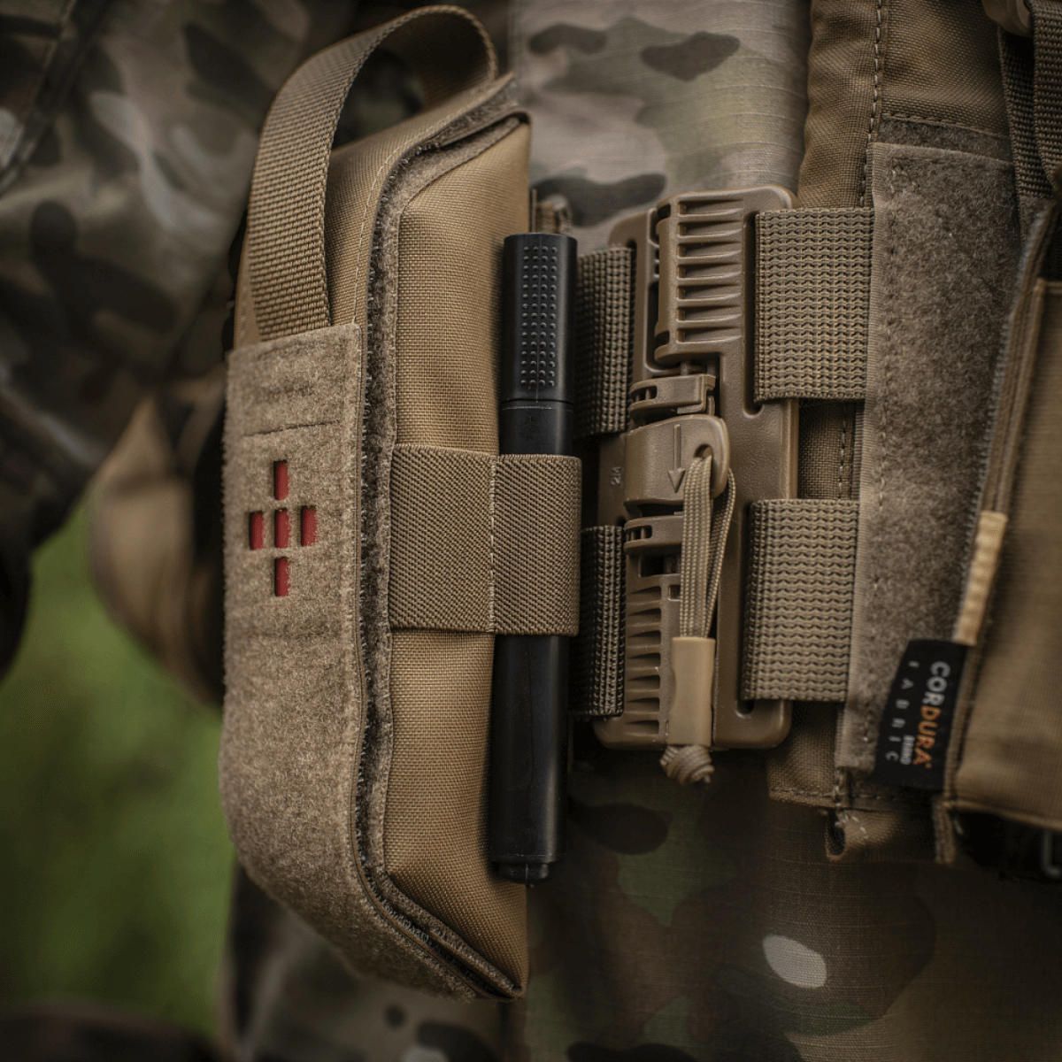 Alt Tag: M-Tac Lomme til Tourniquet Closed monteret på camouflagejakke til førstehjælp i nødsituationer