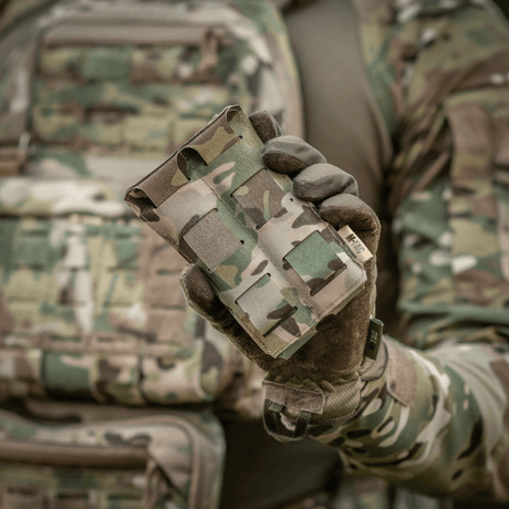 M‑Tac Double Magazine Pouch APS Laser Cut i bruk, hålls av en person i militär camouflagedräkt. Lätt, kompakt design för APS-magasin.