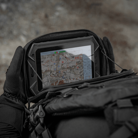 M-Tac Admin Pouch Large Elite i bruk under fältförhållanden för förvaring av taktiska prylar som surfplatta och kartor.